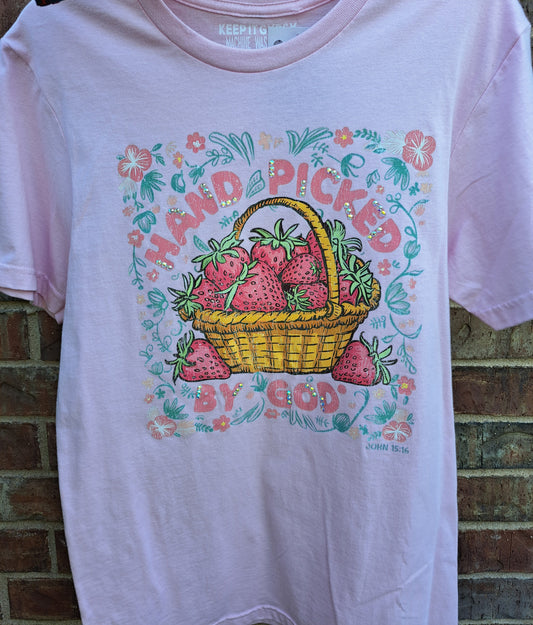 pink tee with strawberries says Hand Picked By God. Brick background