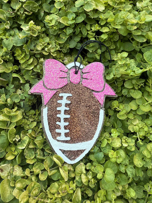 football air freshener on string with pink bow. Greenery background