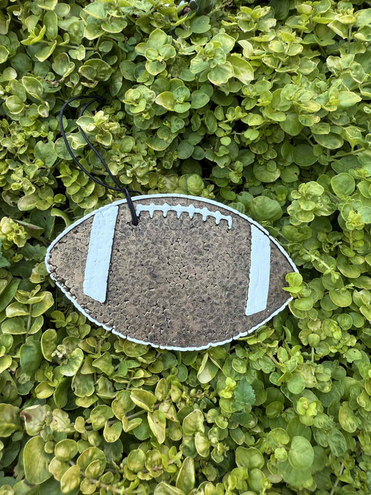 Football-shaped freshie on a green leafy background