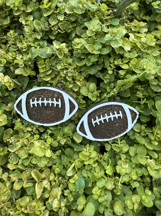Two football-shaped vent clips on a bed of green leaves