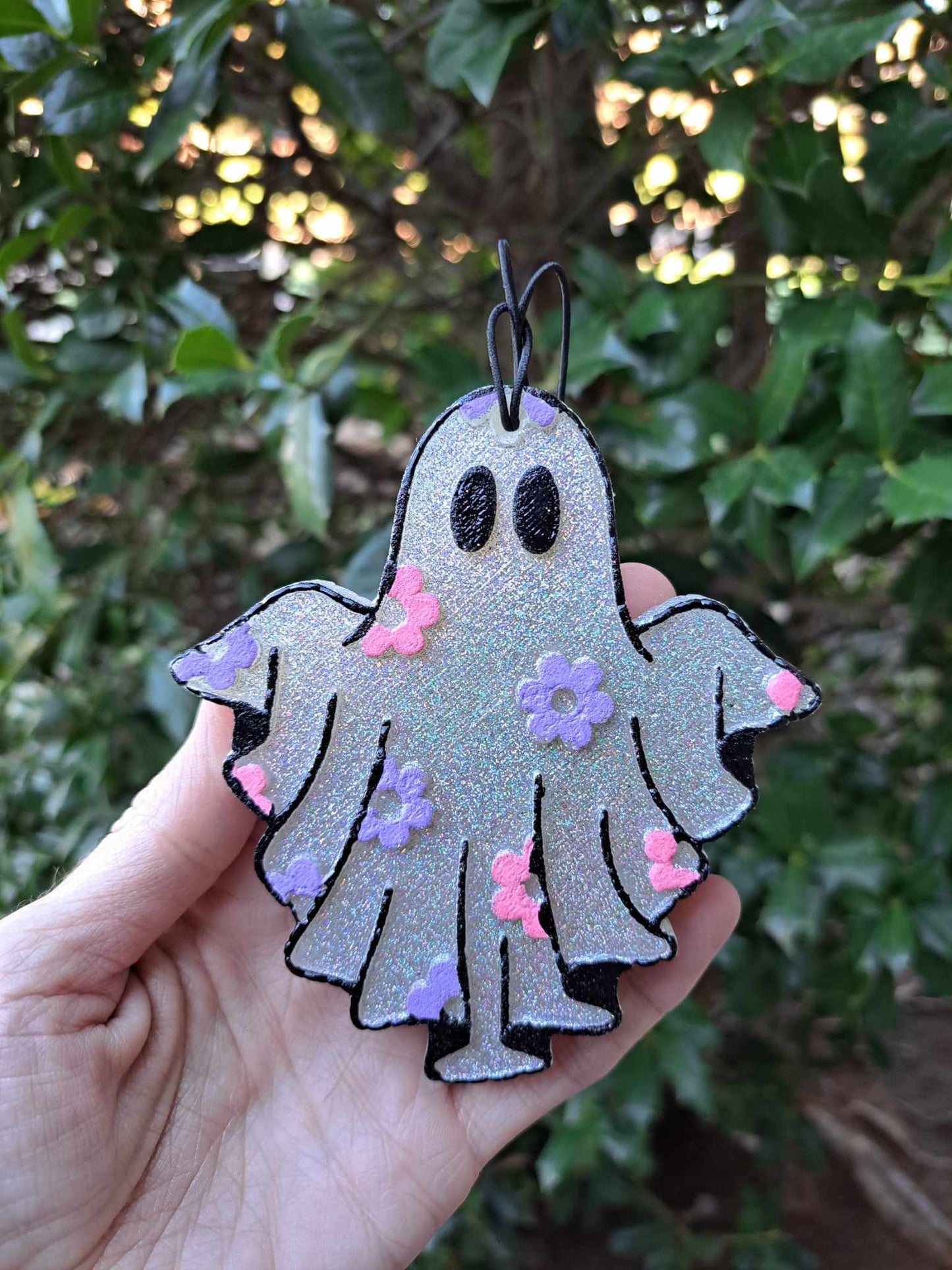 ghost freshie held in front of foilage