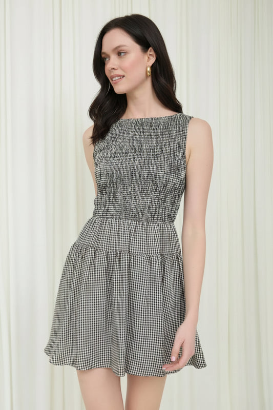 Woman wearing a black and white checkered dress against a white background