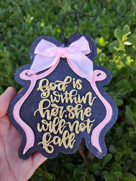 Decorative sign freshie with gold text and pink ribbon held against a green leafy background