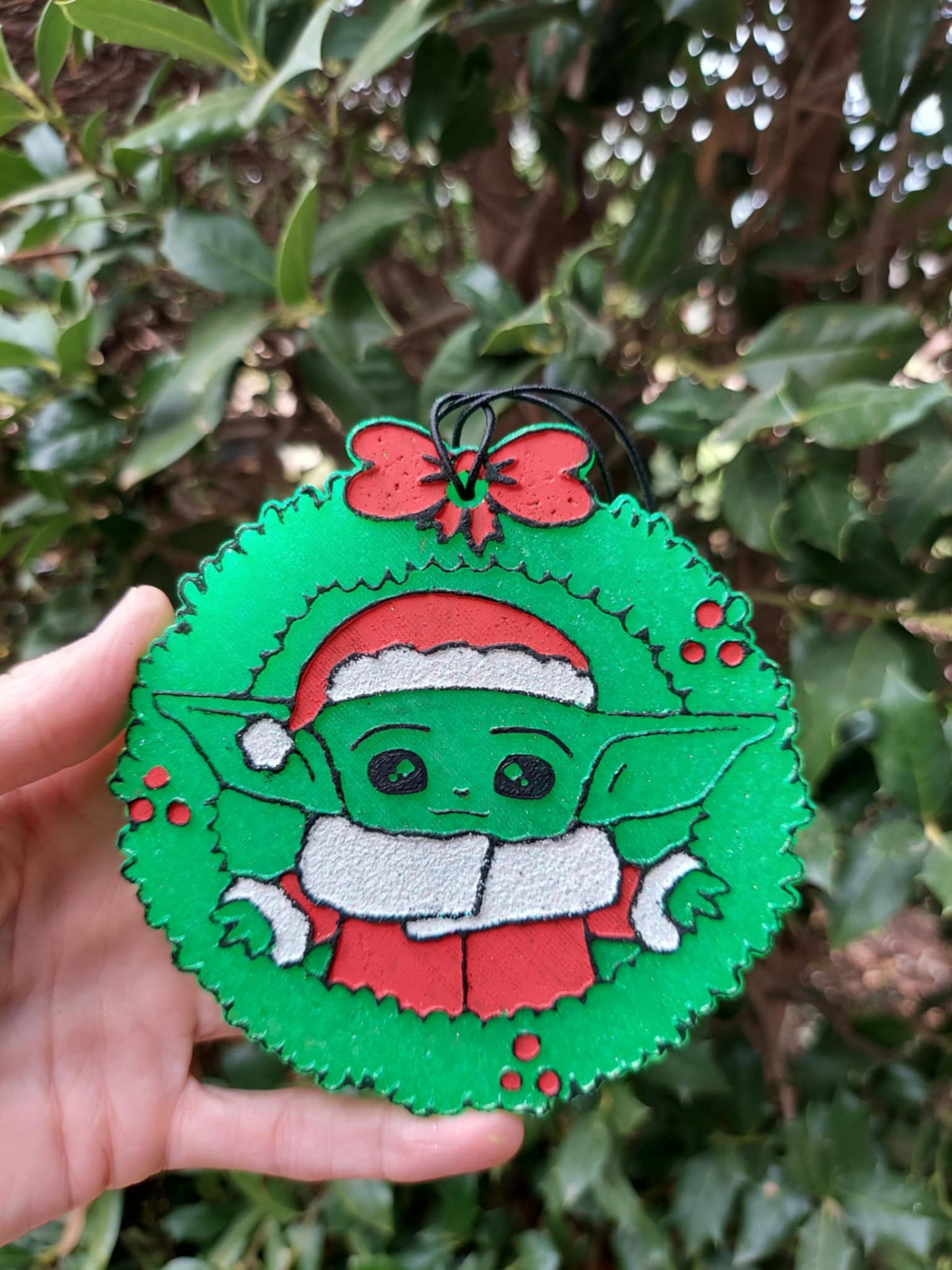 green guy in Santa hat inside a wreath freshie