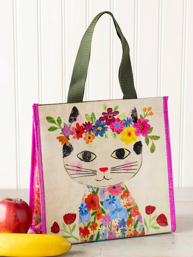 Tote bag with a colorful cat design and floral patterns on a white background