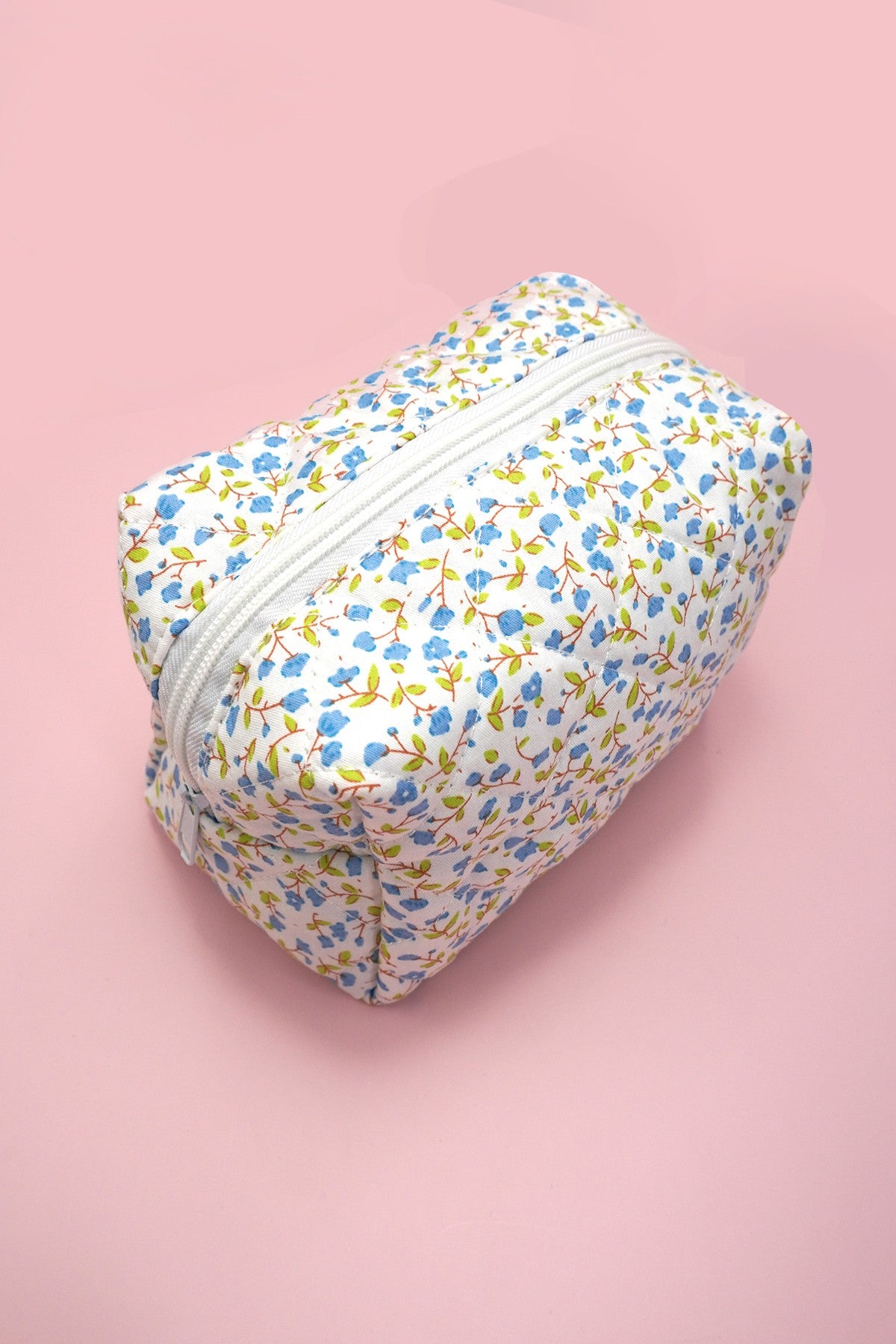 Blue floral-patterned pouch on a pink background