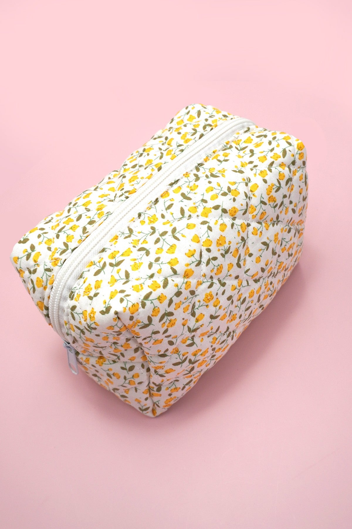 Yellow floral-patterned pouch on a pink background