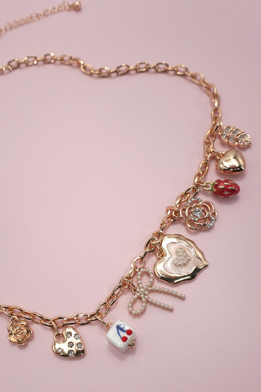 Necklace with various charms on a pink background
