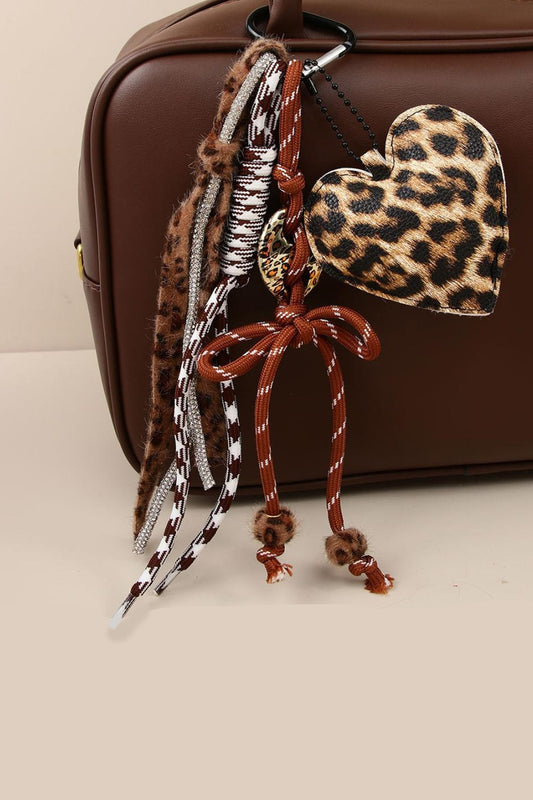 Leopard print heart-shaped keychain with braided design on a brown background