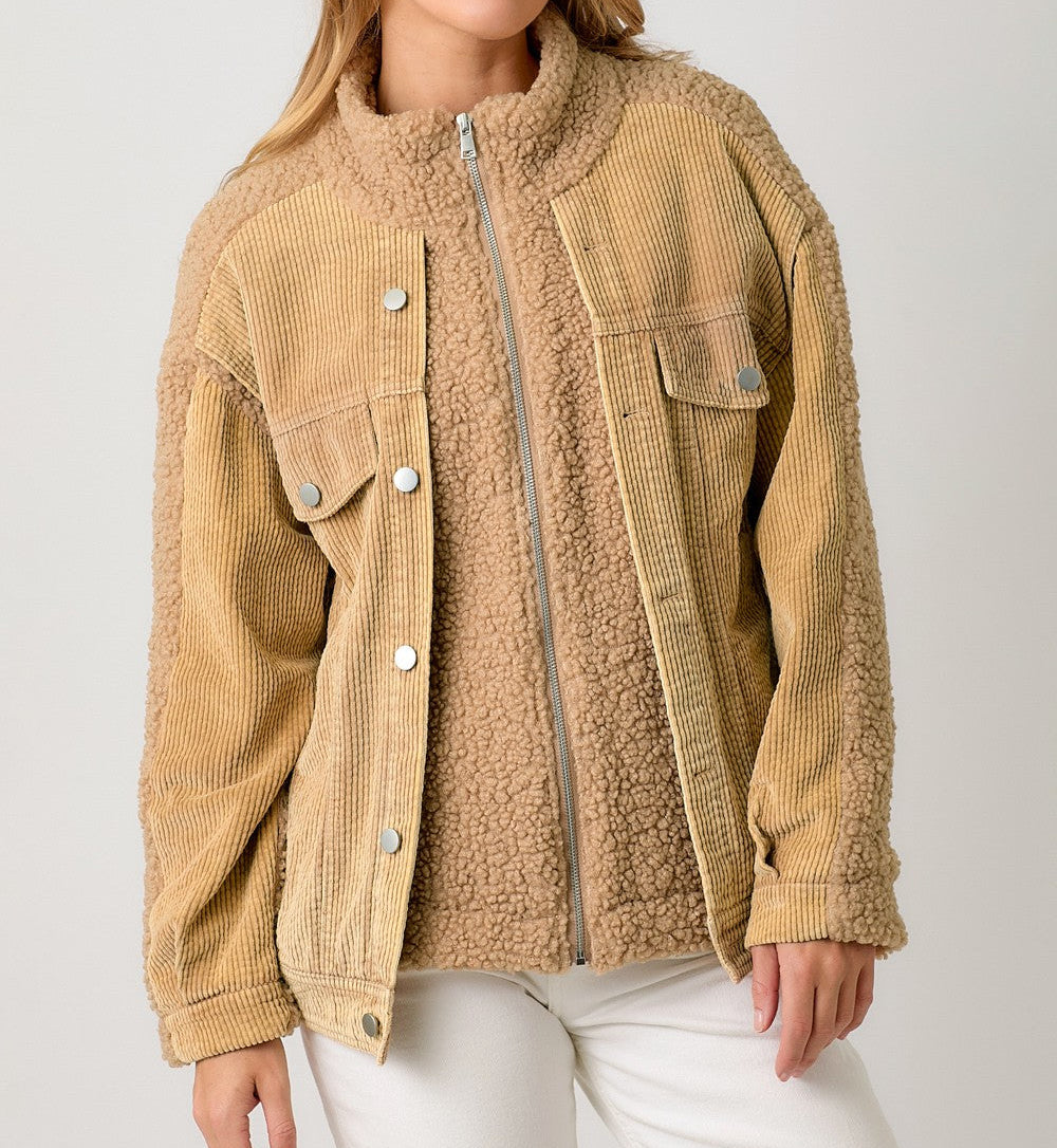 Woman wearing a beige corduroy jacket with a sherpa lining on a white background