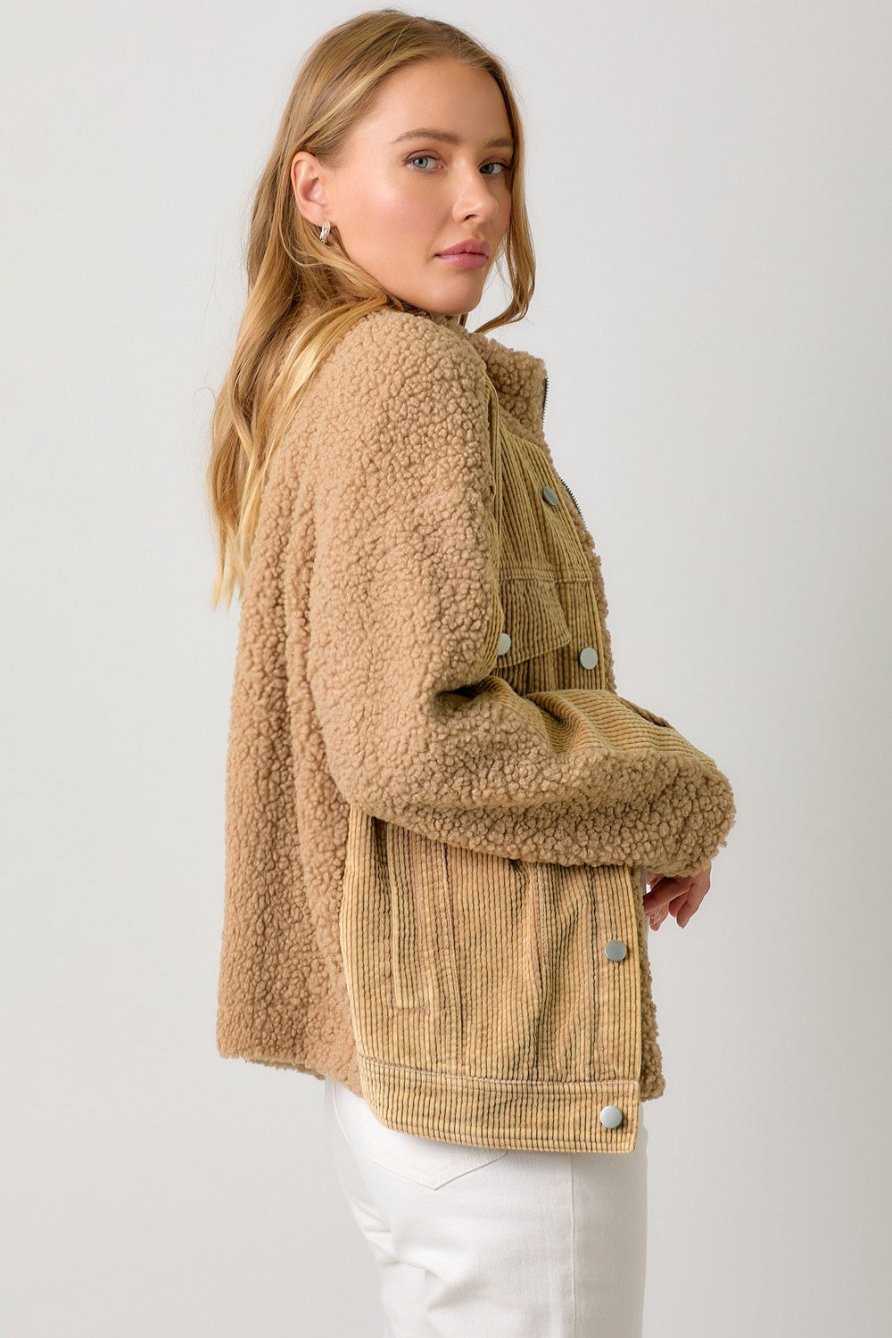 Woman wearing a beige sherpa jacket on a white background