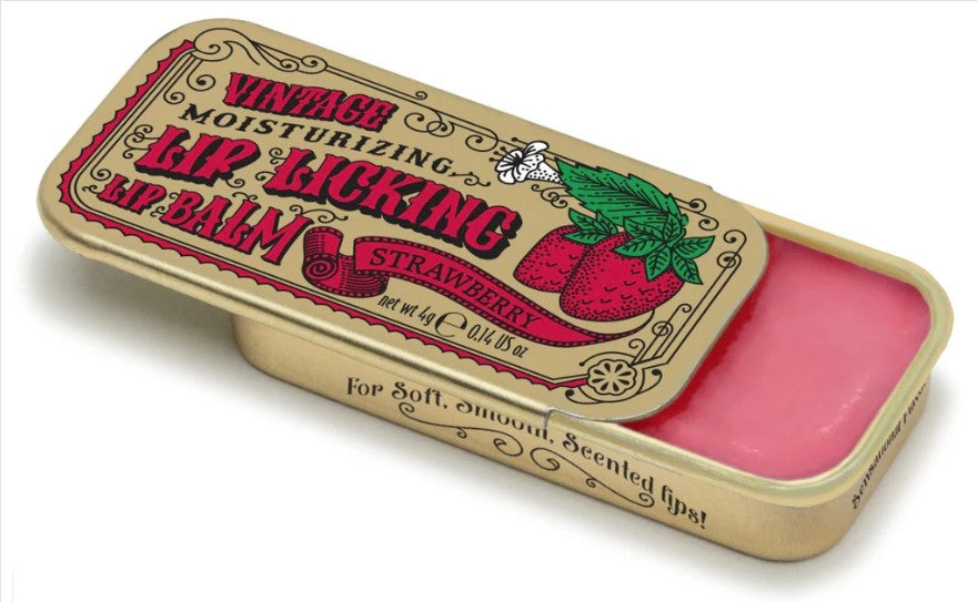 Vintage-style lip balm tin with a pink balm visible inside. The lid is open and features retro text reading 'Vintage Moisturizing Lip Biking Lip Balm' with a strawberry illustration and 'Strawberry' on a cream background.