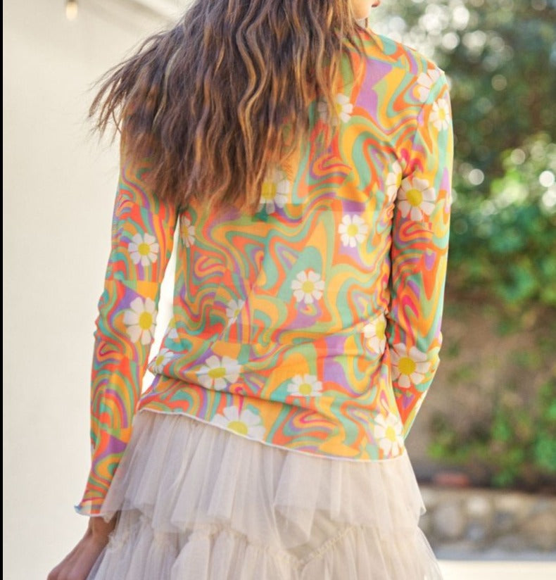 woman wearing daisy mesh top with lace skirt. Back view. Greenery background.