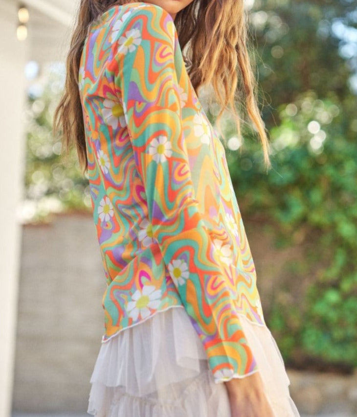 woman wearing daisy print mesh top with lace skirt. Greenery backbround. Side view.