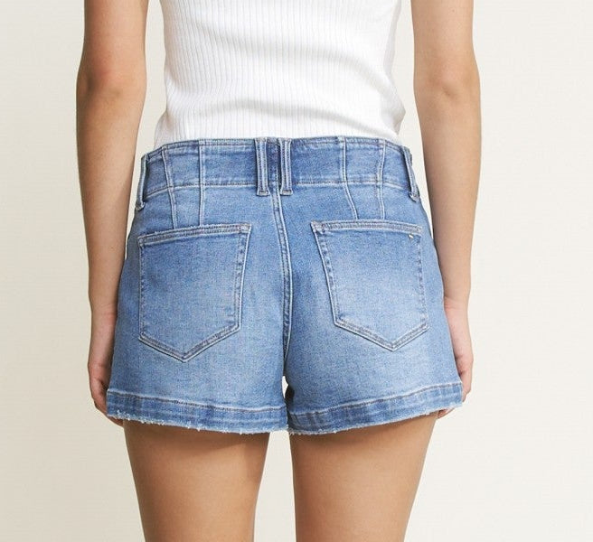 Person wearing a white t-shirt and denim shorts on a plain background