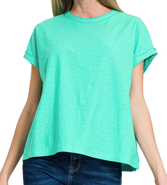 woman wearing a mint green lightweight top with rolled sleeves on a white background