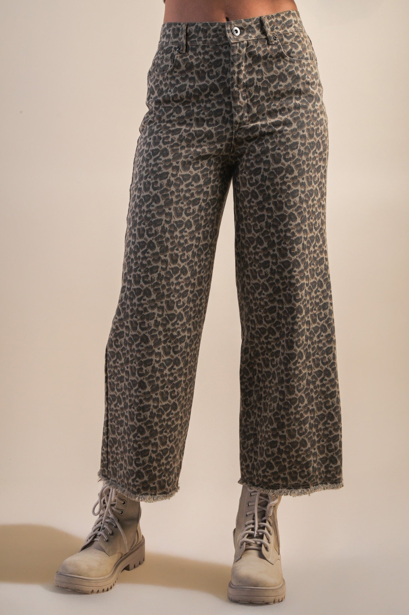 model wearing mocha leopard jeans with boots on a beige background
