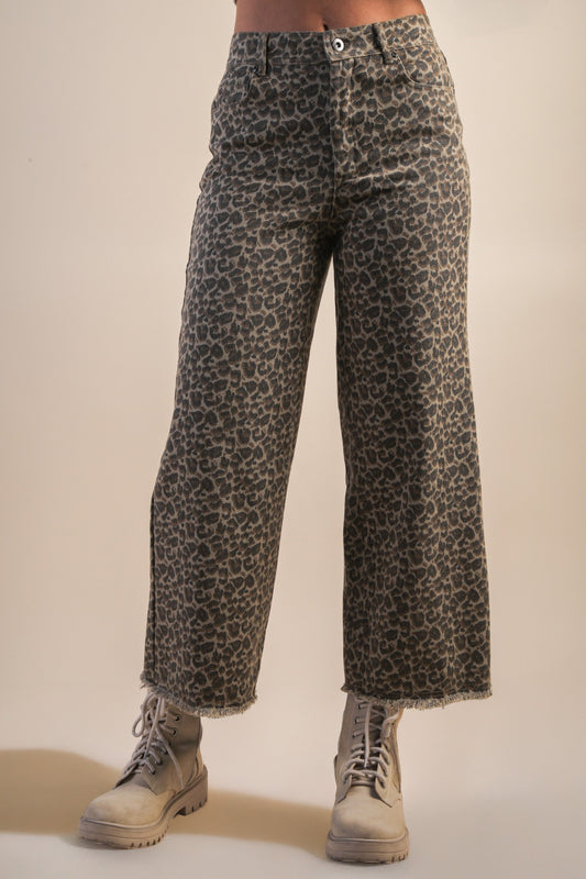 model wearing mocha leopard jeans with boots on a beige background