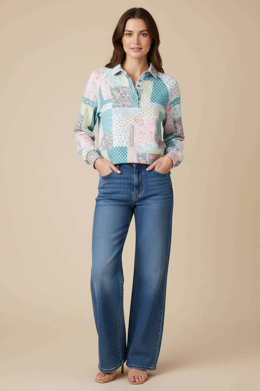 Patchwork top on woman wearing jeans against a neutral background