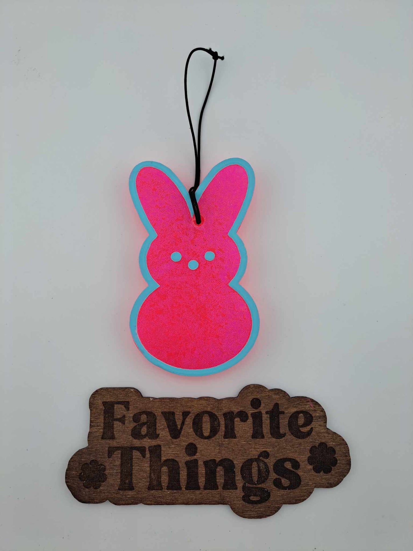 A pink and blue handmade air freshener in the shape of a bunny with 'Favorite Things' written in brown below.