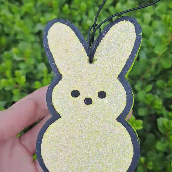 yellow bunny freshie held in front of greenery