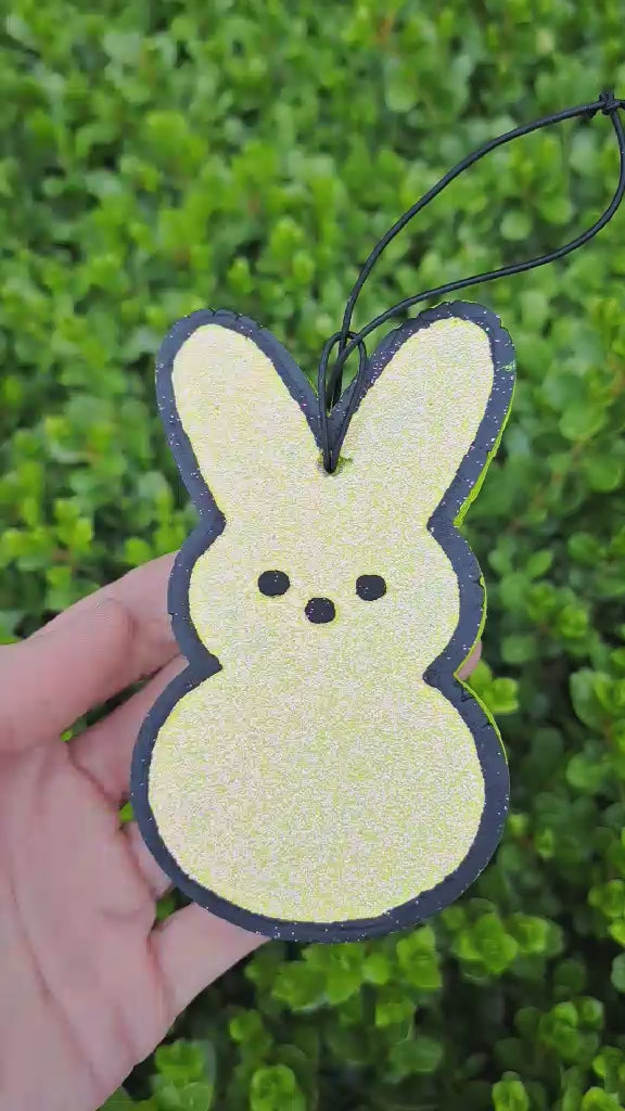 yellow bunny freshie held in front of greenery