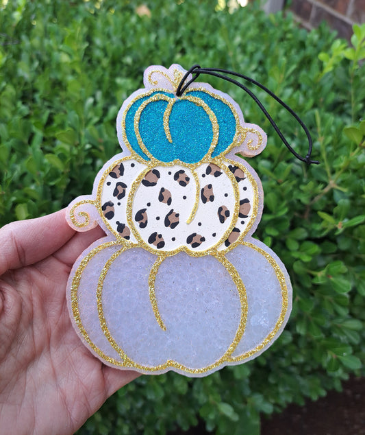 pumpkin stack freshie held in a hand with greenery background