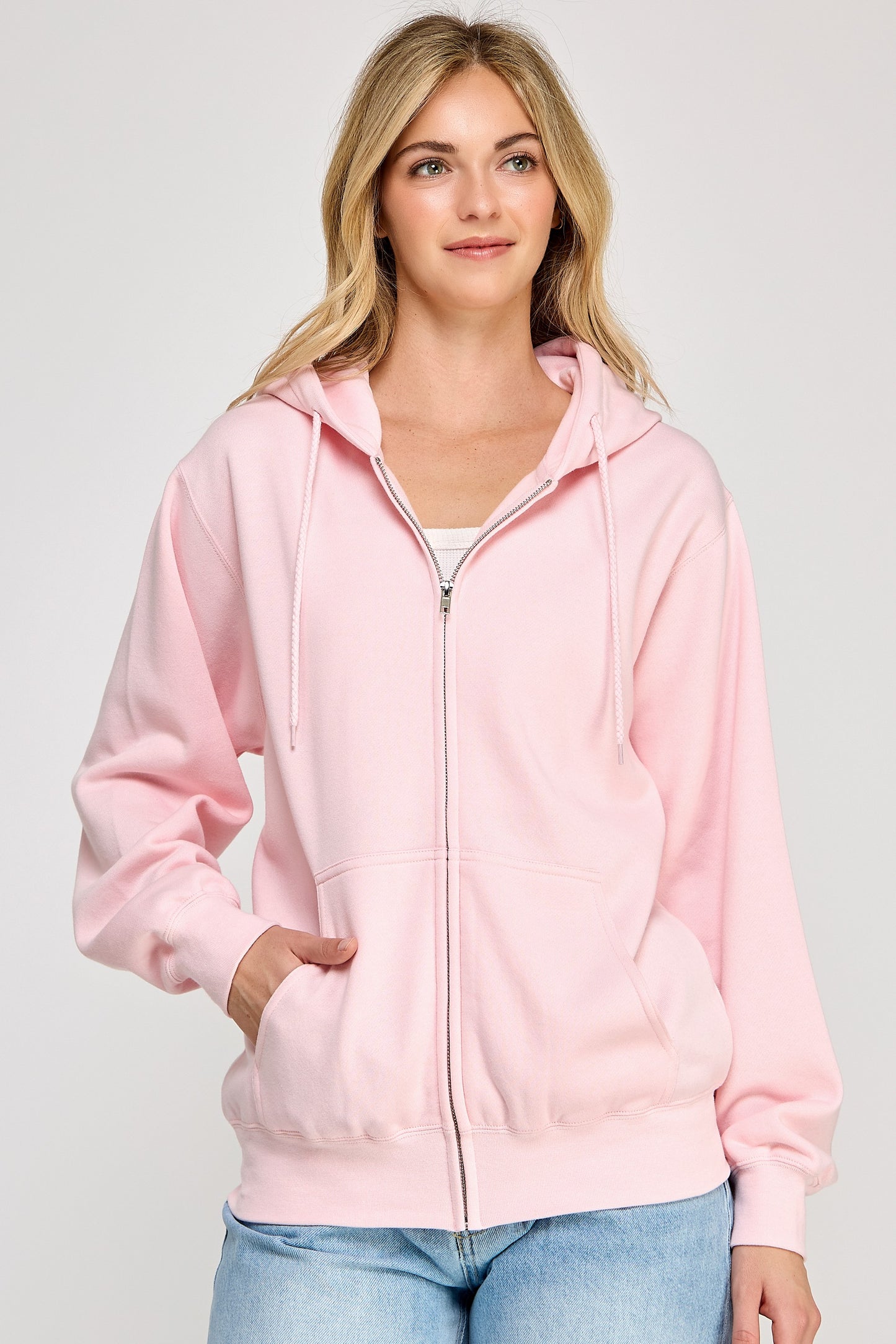 Woman wearing a pink hoodie on a plain background