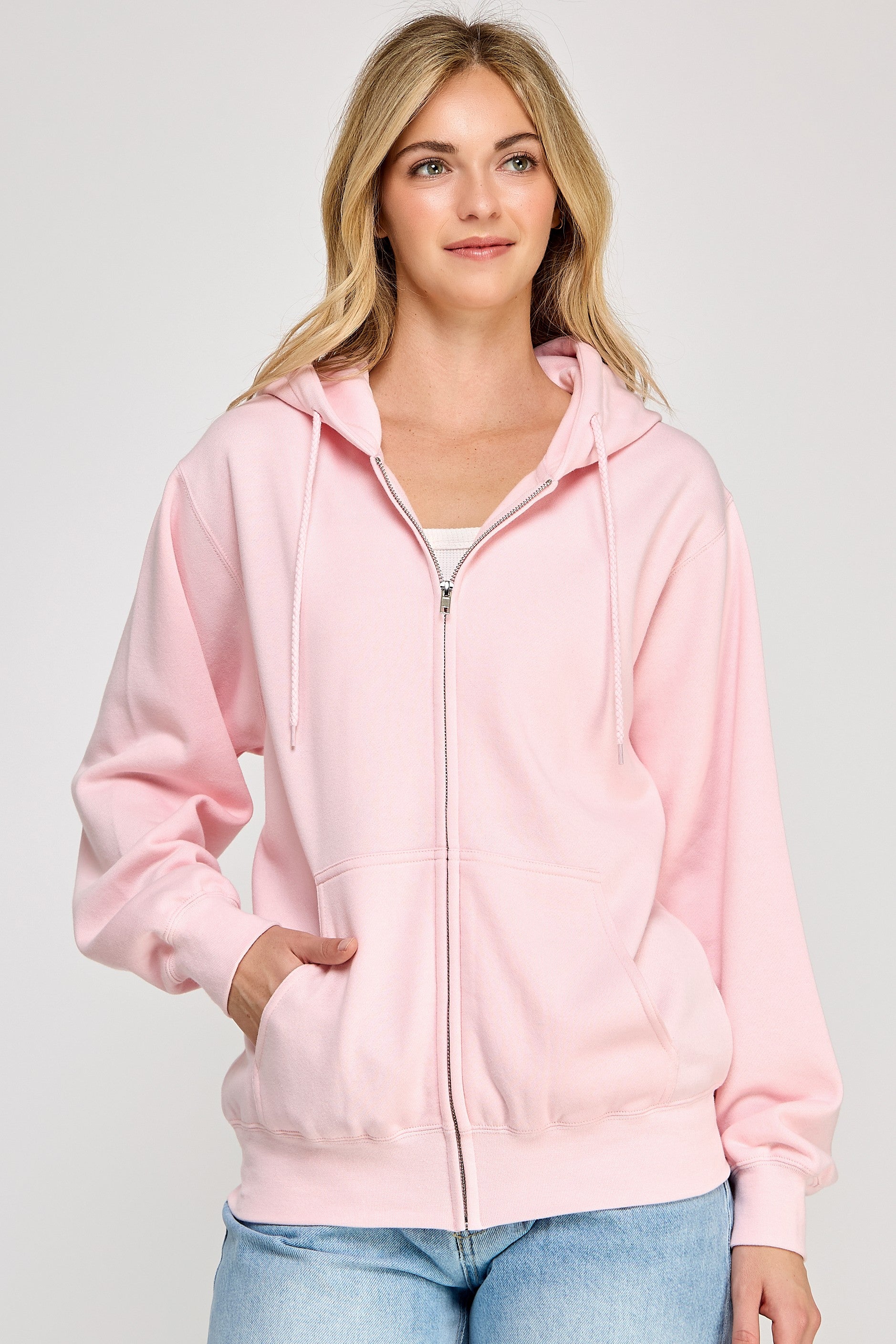 Woman wearing a pink hoodie on a plain background