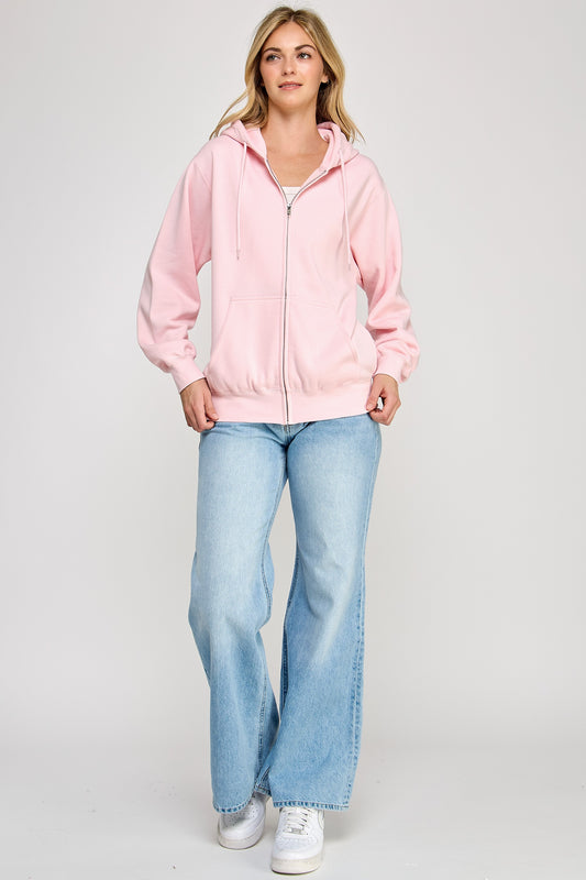 Woman wearing a pink jacket and light blue jeans on a white background