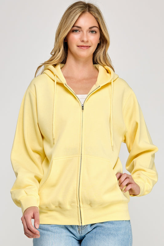 Woman wearing a yellow hoodie on a plain background