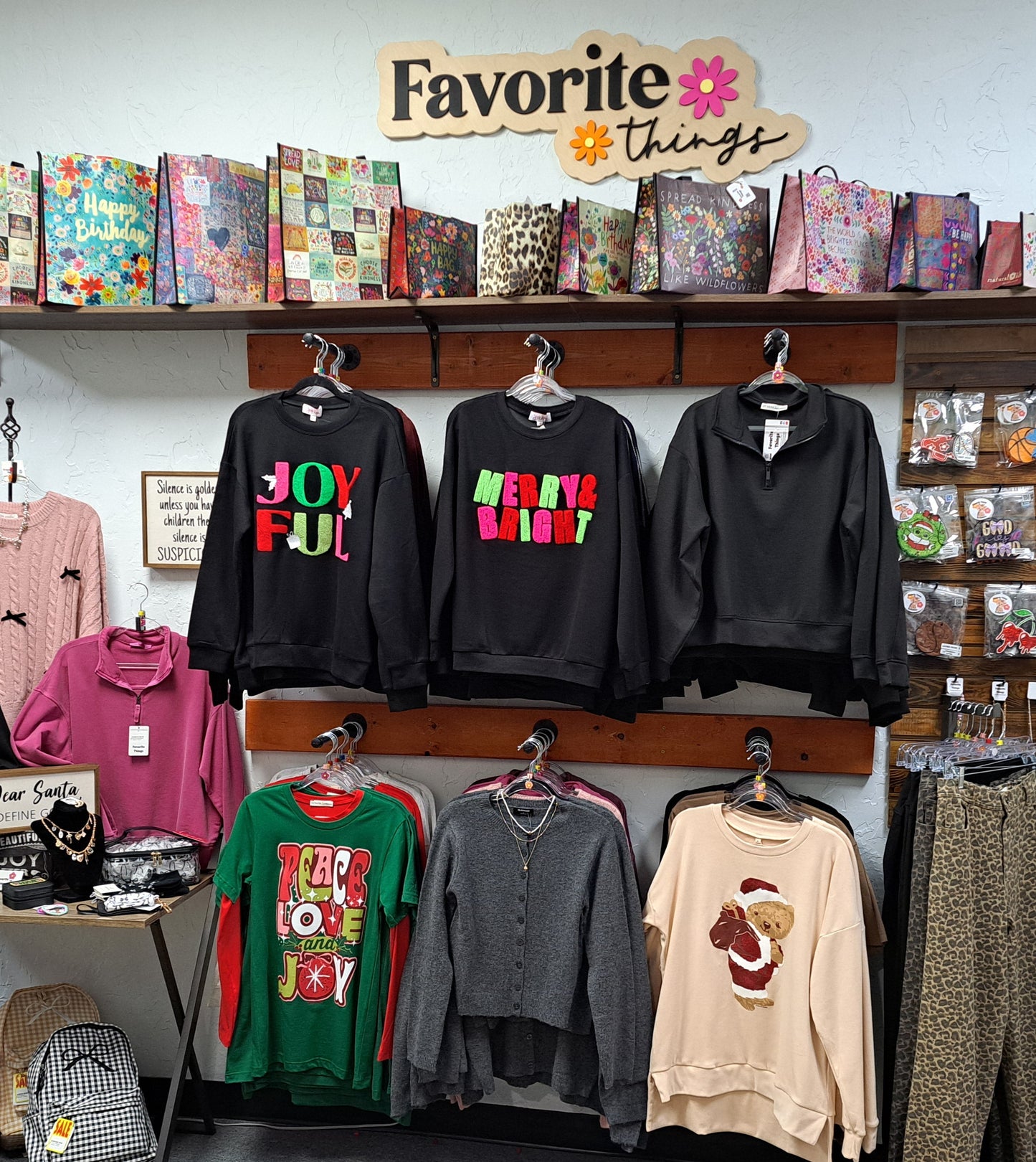 Display of clothing with colorful text and 'Favorite Things' sign above in a store.