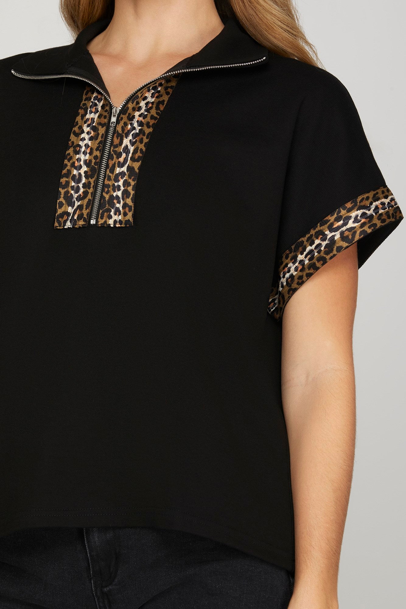 Black top with leopard print accents on a plain background