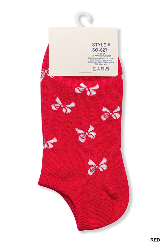 A pair of red ankle socks with white bow print, displayed with packaging.