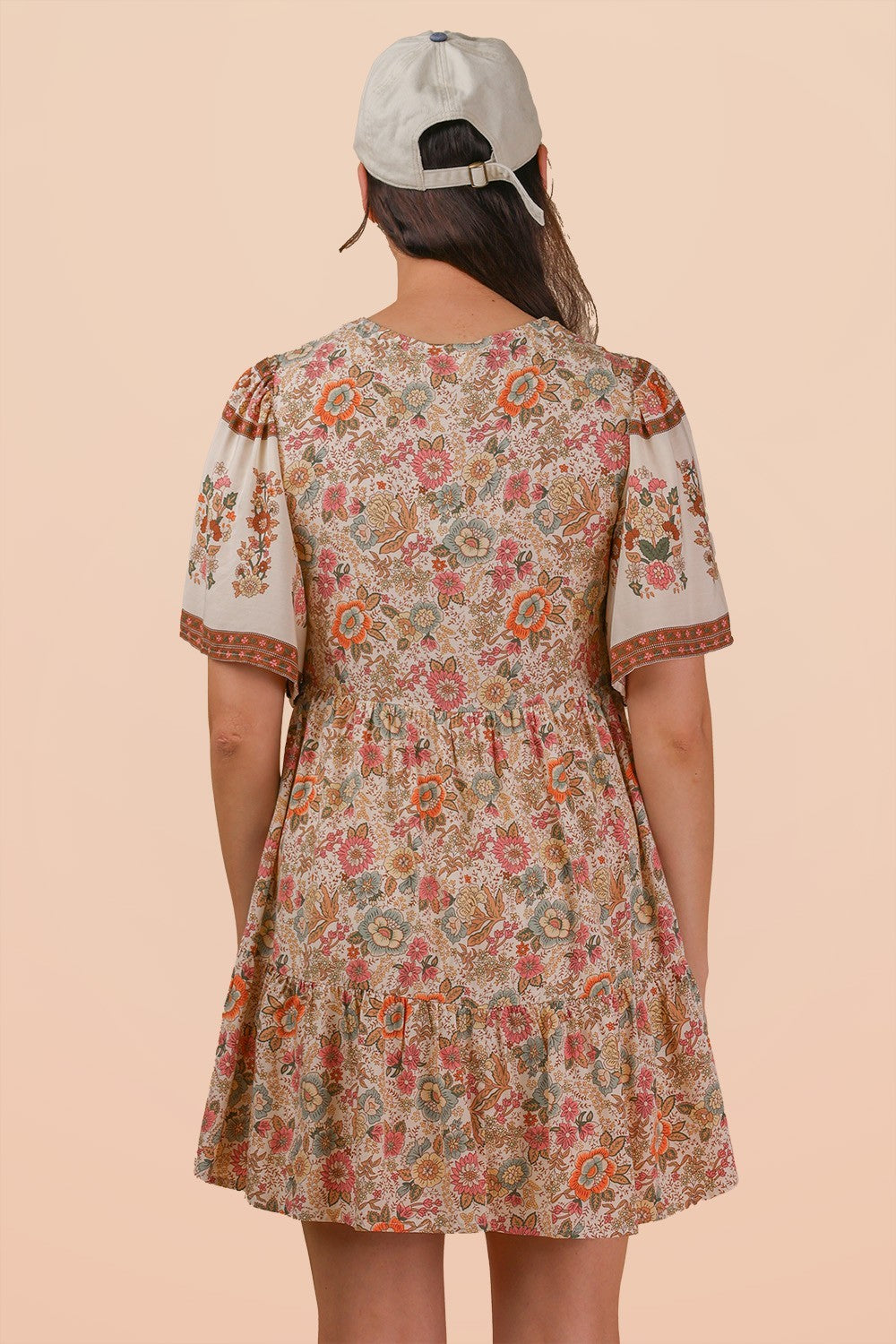 Woman wearing a floral dress with a beige background