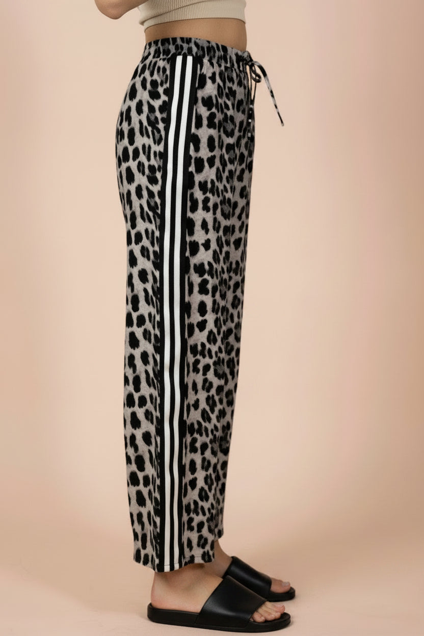 Leopard print pants with white stripes on a beige background