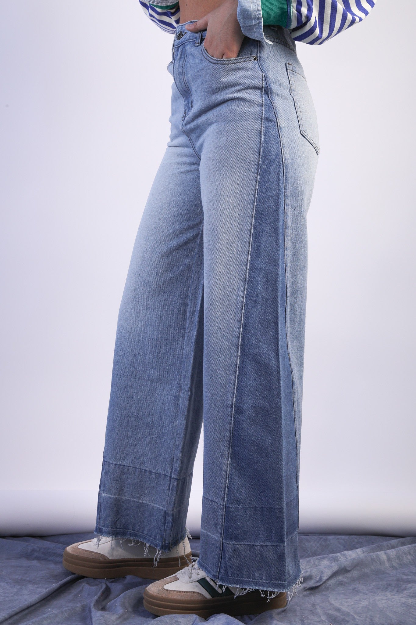 Person wearing light blue wide-leg jeans on a white background