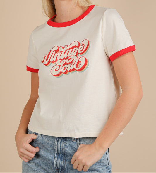 Woman wearing a white t-shirt with red trim and 'Vintage Soul' text on a beige background