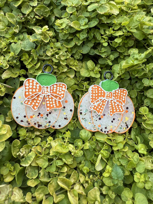 White pumpkin-shaped vent clip freshies with polka dot orange bows on a green leaf background