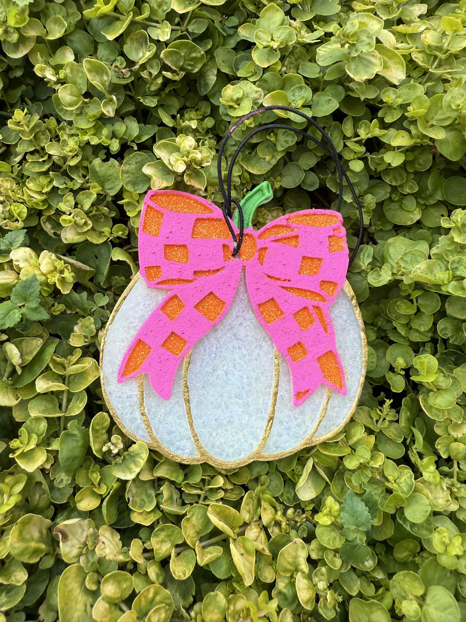 White pumkin freshie with checkered bow. Greenery backround