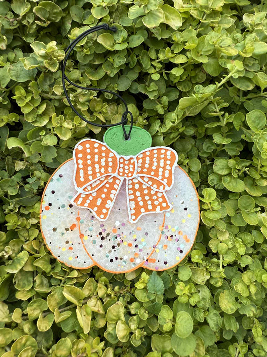 Decorative pumpkin freshie with a bow on a green leaf background