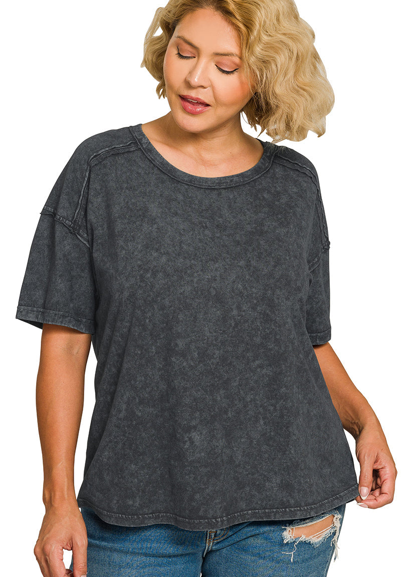 Woman wearing a black acid-wash t-shirt and jeans on a white background