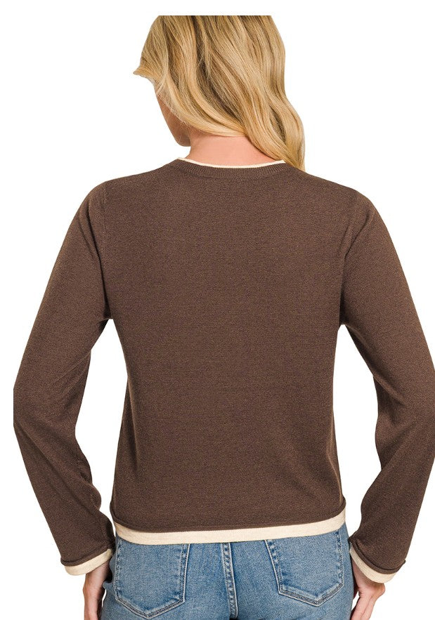 A woman viewed from the back wearing a brown long-sleeve knit top with cream ribbed trim at the crew neck, cuffs, and hem, paired with blue jeans against a white background.