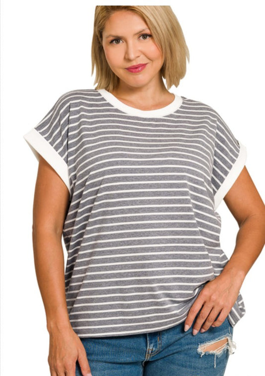 Woman wearing a gray and white striped t-shirt with blue jeans on a white background