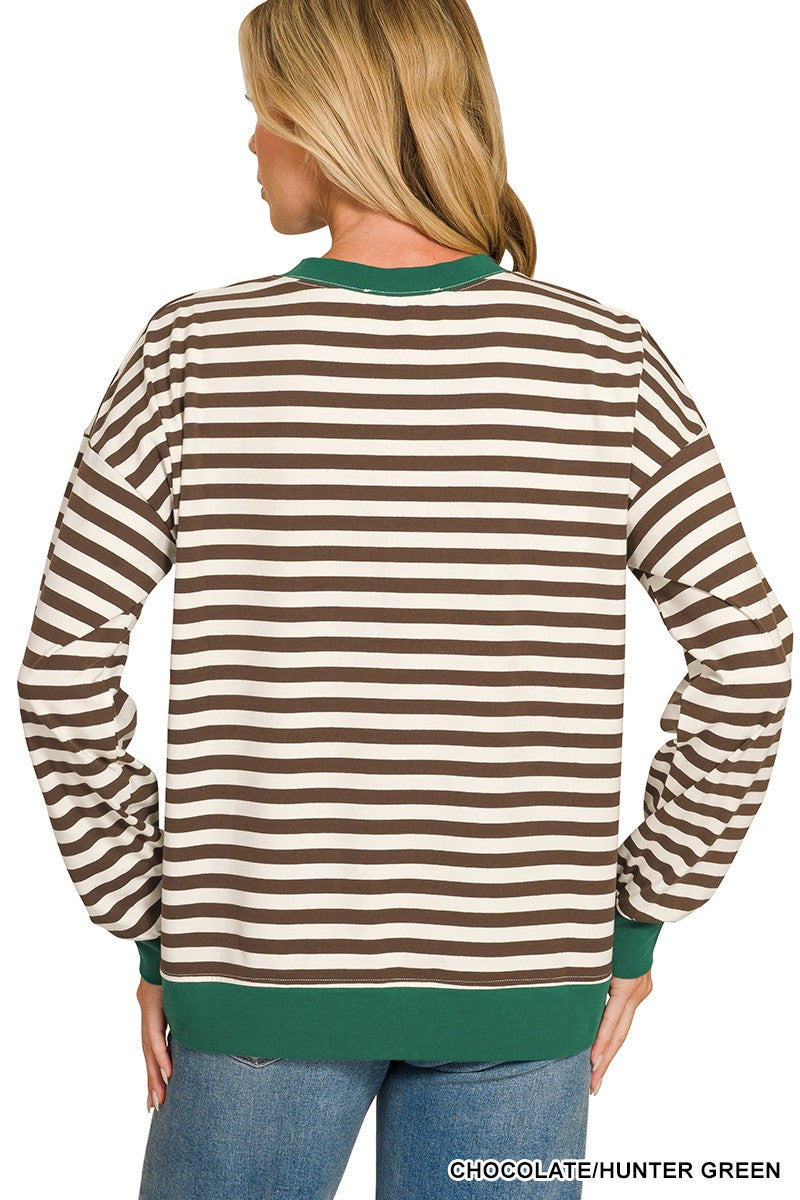 A woman shown from the back wearing a long-sleeve crewneck sweatshirt with horizontal brown and cream stripes, finished with solid chocolate hunter green ribbed trim at the collar, cuffs, and hem, paired with blue jeans against a white background.