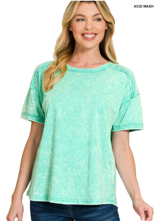 Woman wearing a light green acid wash t-shirt on a white background