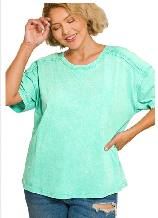 Woman wearing a light green t-shirt and blue jeans on a white background
