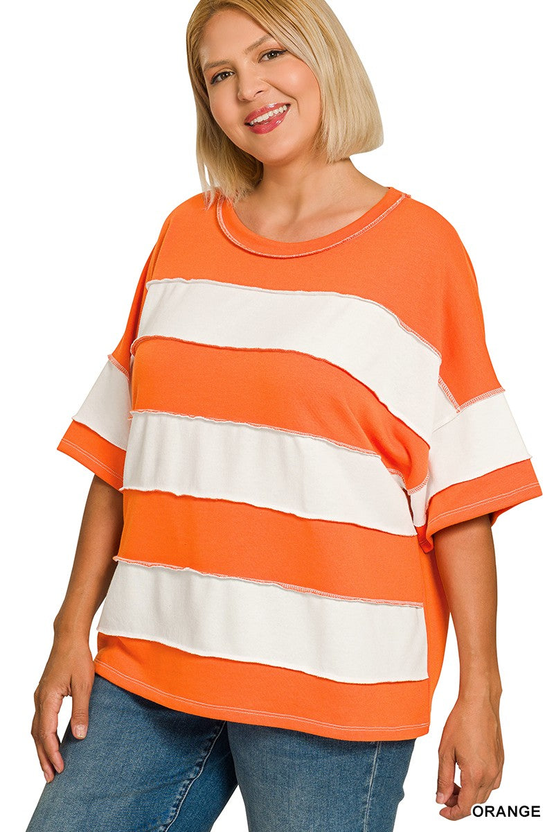Woman wearing an orange and white striped shirt with blue jeans on a white background