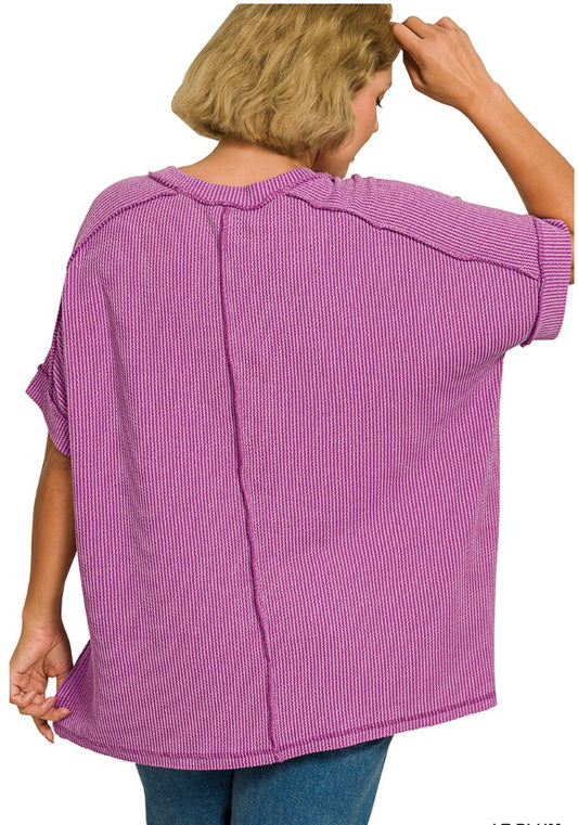 Person wearing a purple textured top with short sleeves on a white background