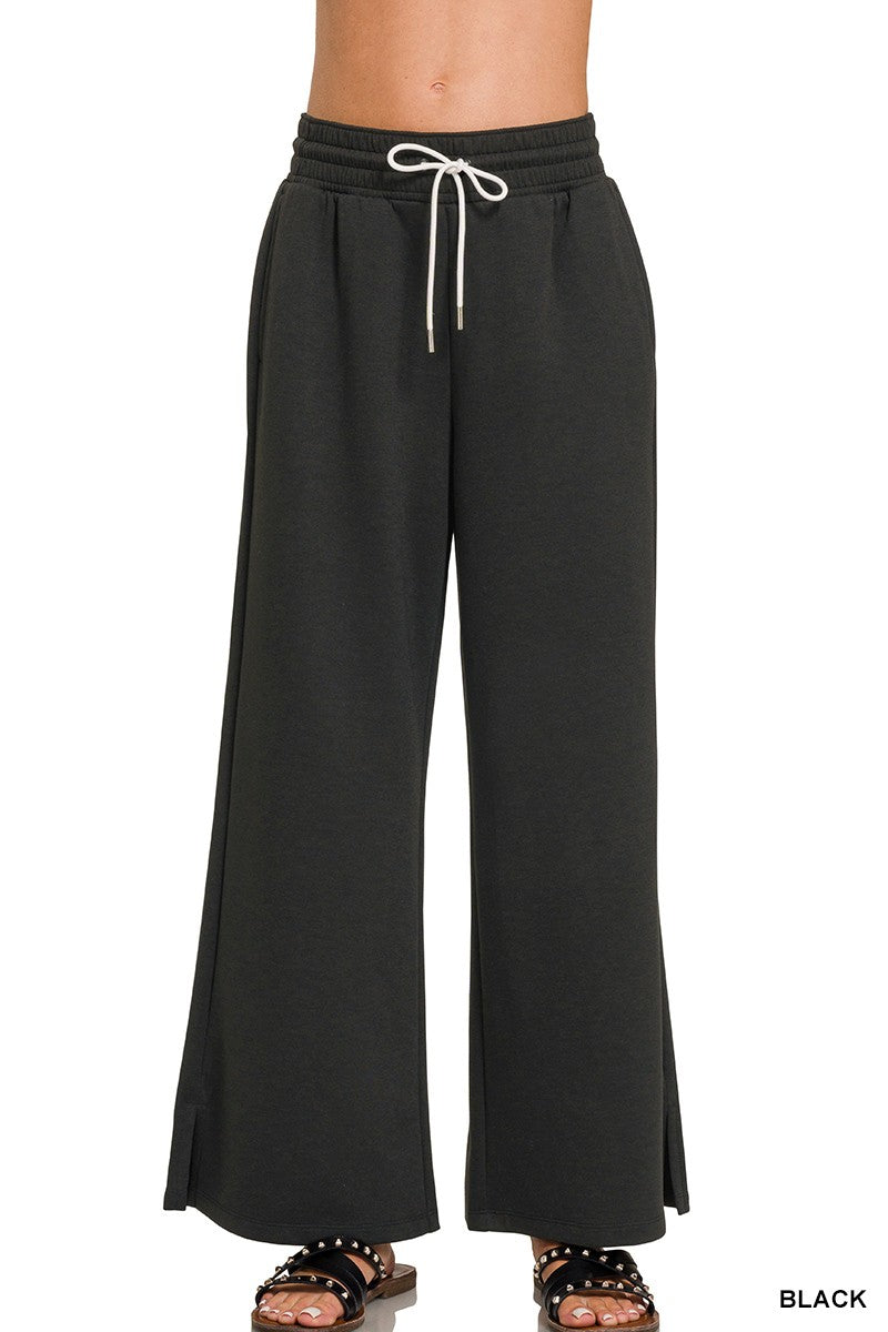 Black wide-leg pants with a drawstring waist on a white background